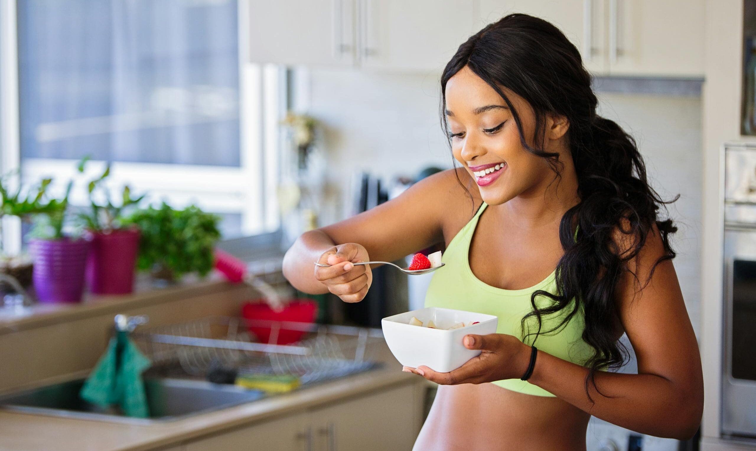 Woman Eating Strawberry in the Kitchen